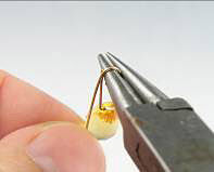 Pliers wrapping wire onto a bead